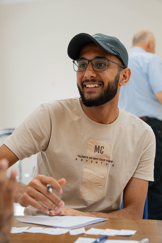 Student smiling while working with notes at a table