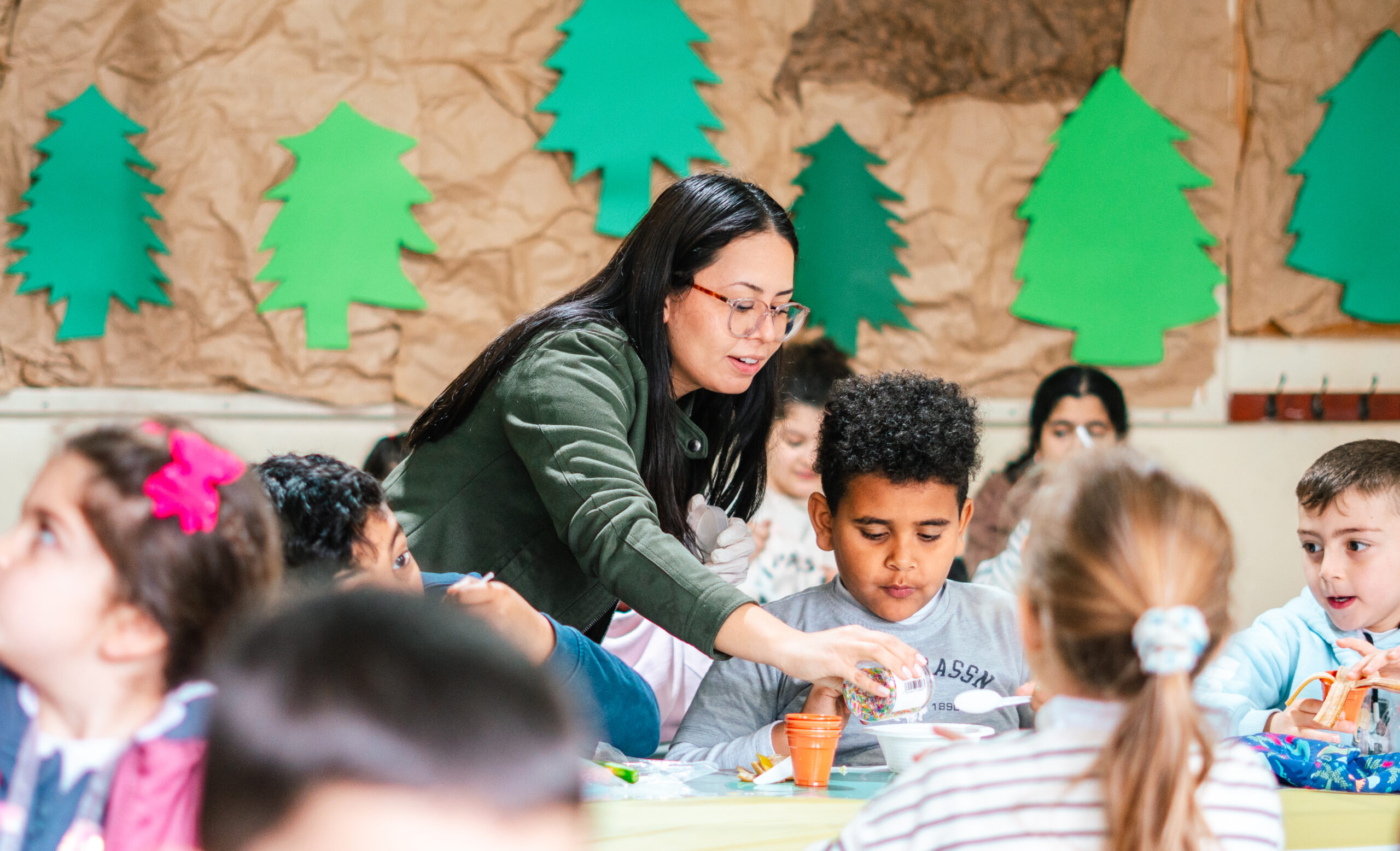 Adult guiding a group of children during a hands-on learning activity