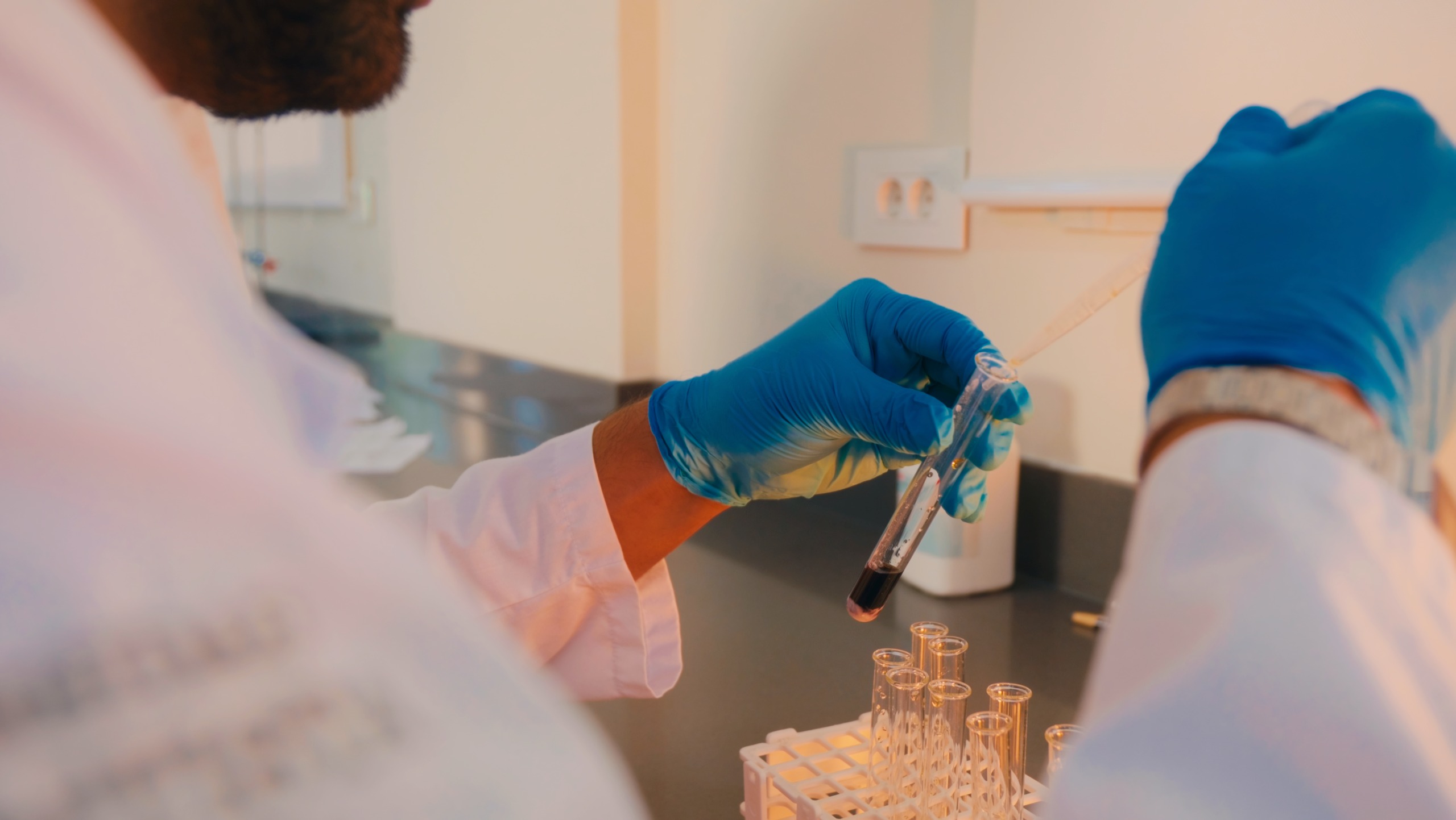Close-up of biotechnology laboratory work with glassware and test tube handling