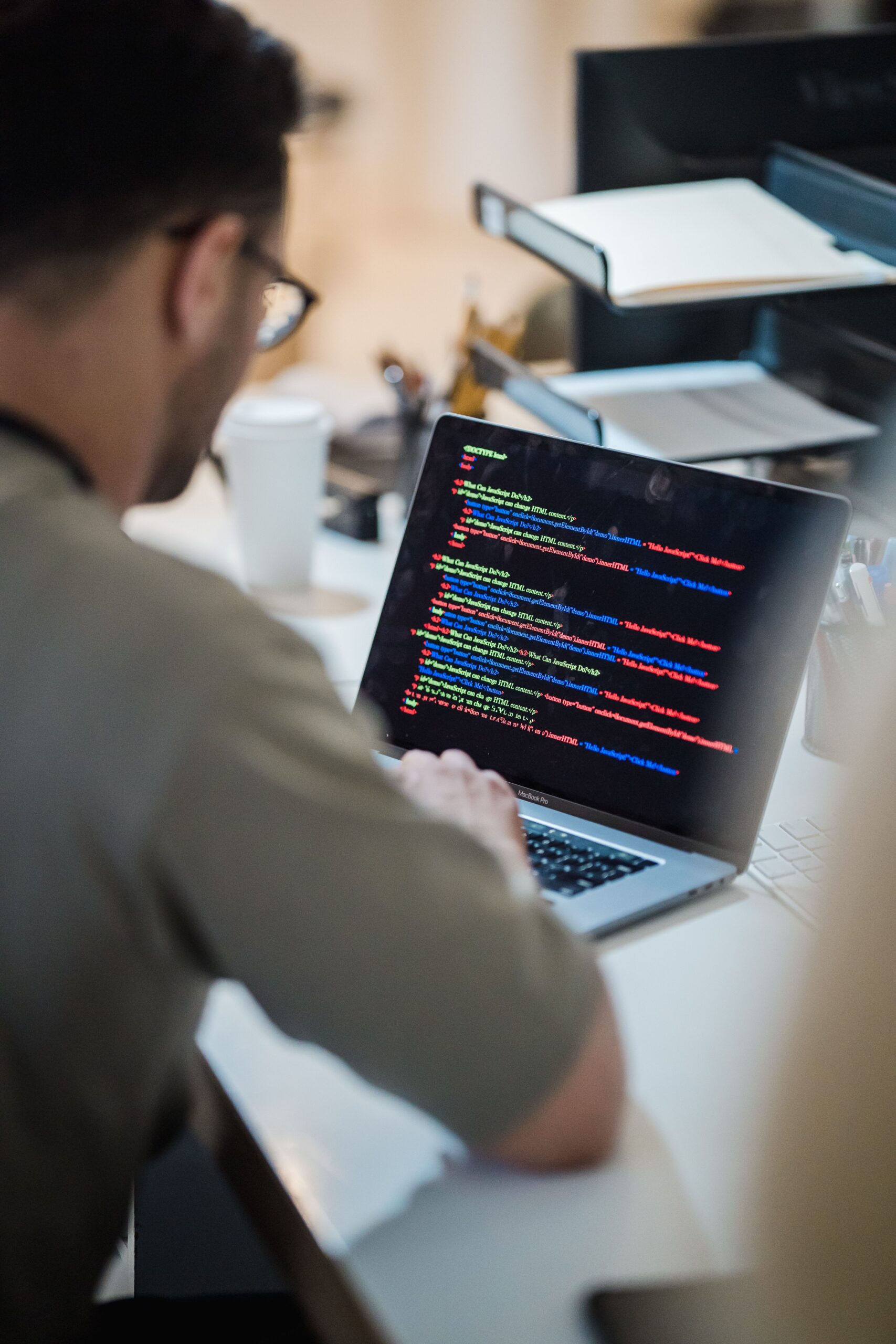 Person working at a laptop with code displayed on the screen